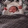 baby, sleeping, blanket, cozy, fuzzy_outfit, infant, soft_toys, patterned_background, knitted_blanket, cute, peaceful, child, portrait, indoors, comfort, warm, adorable, resting, young_child, headwear