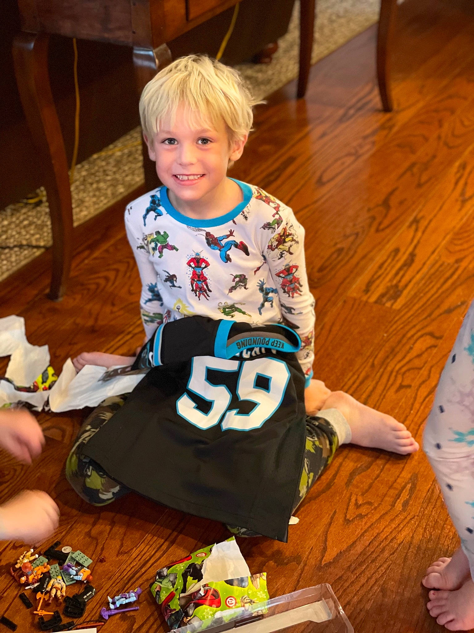 John Thomas is registered to the contest to win money with this photo: child, event, flooring, fun, happy, hardwood, holiday, joy, leisure, pattern, person, play, recreation, sitting, sleeve, smile, t_shirt, toddler, varnish, wood