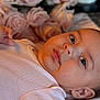 Adele is registered to the contest to win money with this photo: baby, infant, portrait, face, skin, eyes, pink_clothing, blanket, roses, flowers, soft_texture, closeup, cute, child, newborn, head, ear, peaceful, lying_down, indoor