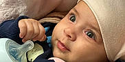 Adele joined the competition — help win amazing prizes! baby, bottle, blanket, hat, clothing, face, hand, infant, closeup, cute, expression, indoors, newborn, person, portrait, sitting, soft, toddler, warm, wearing