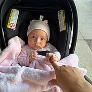 Adele joined the competition — help win amazing prizes! baby, infant, car_seat, blanket, pink, hat, hand, finger, keys, car_key, sidewalk, outdoor, person, child, cute, expression, curious, transportation, urban, street