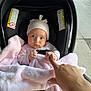 baby, infant, car_seat, blanket, pink, hat, hand, finger, keys, car_key, sidewalk, outdoor, person, child, cute, expression, curious, transportation, urban, street