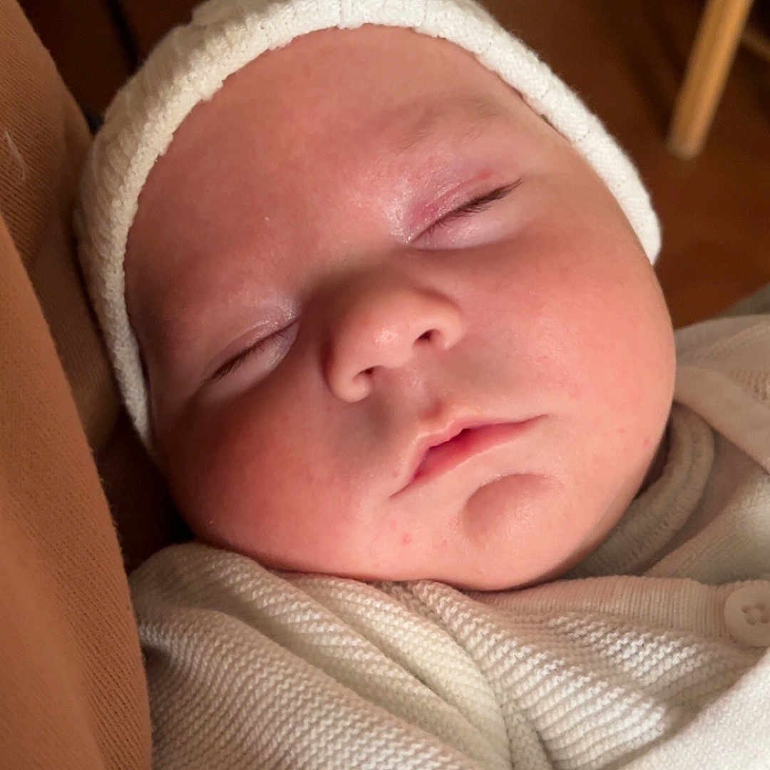 Francky a rejoint le concours — aidez-le/la à gagner de superbes lots ! baby, calm, child, close_up, cozy, cute, face, indoor, infant, knitwear, newborn, peaceful, portrait, resting, skin, sleeping, soft_lighting, warm_colors, white_hat, white_sweater