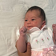 Vashti is registered to the contest to win money with this photo: baby, bed, blanket, child, clothing, cute, dress, embroidery, expression, face, fist, hand, infant, lying, newborn, person, pink, portrait, skin, white
