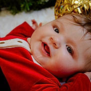 Nova joined the competition — help win amazing prizes! baby, infant, smiling, red_dress, christmas, holiday, festive, gold_ornaments, soft_surface, happy, face, portrait, closeup, person, child, cute, holiday_decor, christmas_theme, cozy, celebration