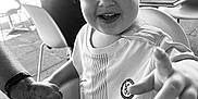 Ronnie joined the competition — help win amazing prizes! adult_hand, baby, black_and_white, cafe, chair, chelsea_football_club, child, close_up, curly_hair, hand_holding, happy, high_chair, jersey, outdoor, person, playful, portrait, smiling, table, toddler