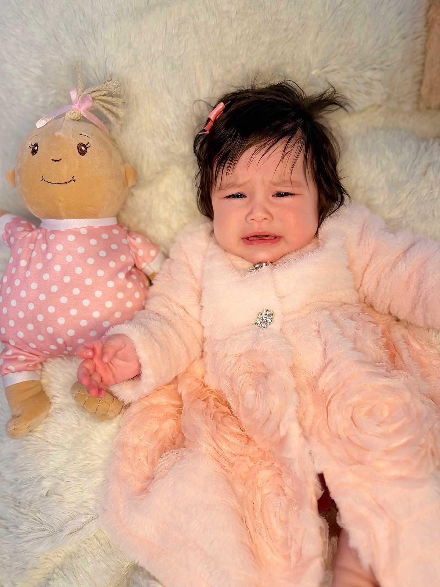 Izzy is registered to the contest to win money with this photo: baby, child, infant, plush_doll, toy, pink, polka_dot, soft_blanket, fur_coat, cute, indoor, portrait, expression, fussy, hand, hair_clip, fabric, comfort, lying_down, cozy