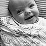 baby, smiling, blanket, wrapped, face, infant, happy, portrait, head, cute, child, striped_background, patterned_cloth, closeup, expression, young, indoors, newborn, skin, eyes