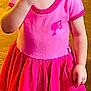Aurora joined the competition — help win amazing prizes! child, girl, pink_dress, smiling, eating, indoor, curly_hair, pigtails, black_shoes, tights, wooden_floor, happy, portrait, young_child, cute, snack, standing, clothing, person, home