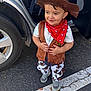 Yamari joined the competition — help win amazing prizes! toddler, child, cowboy_costume, hat, bandana, vest, pants, sneakers, car, parking_lot, door_open, asphalt, white_line, outdoor, smiling, standing, cute, fashion, playful, young_child