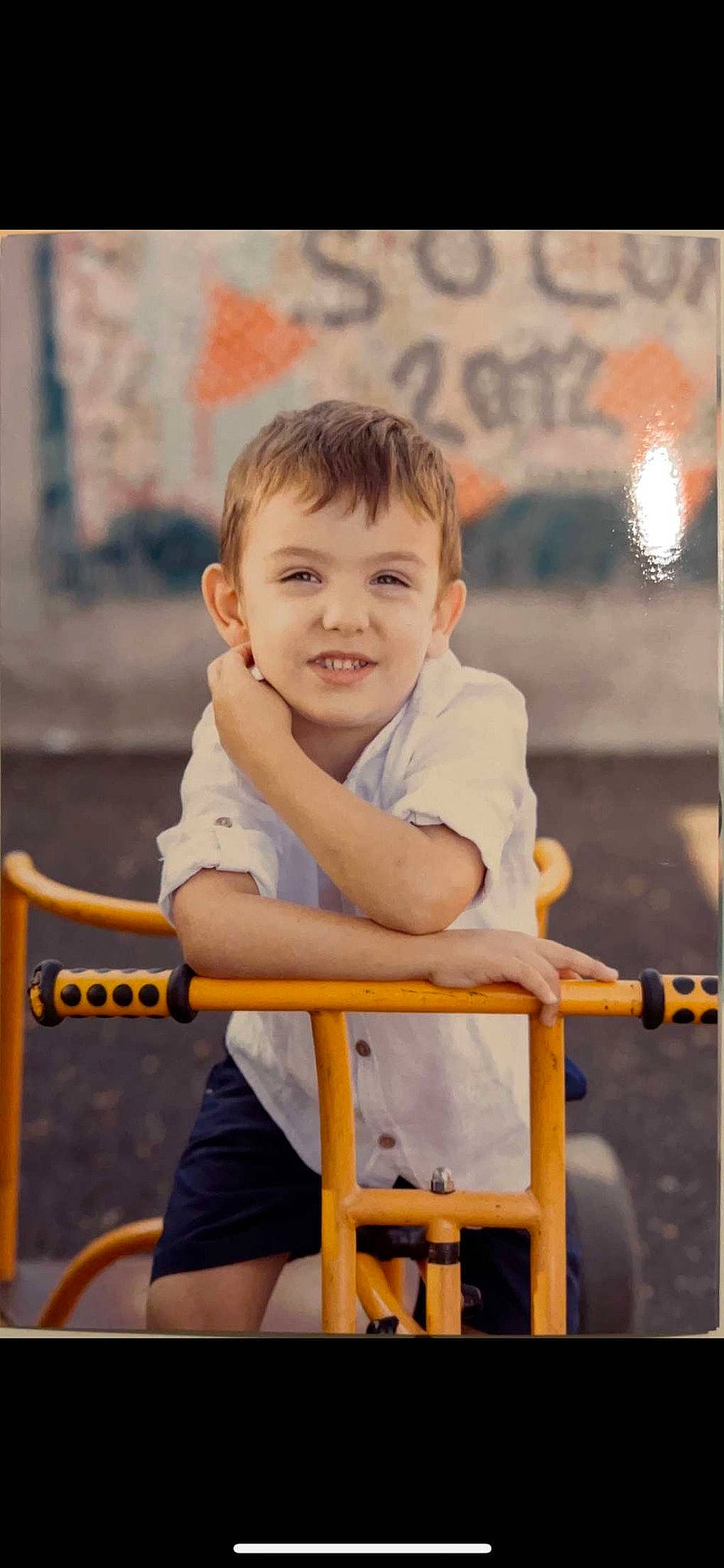 Kélyan a rejoint le concours — aidez-le/la à gagner de superbes lots ! baby_toddler_clothing, chair, child, fun, happy, joy, leisure, orange, person, portrait_photography, room, shorts, sitting, sleeve, smile, t_shirt, toddler, vacation, wood