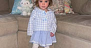 Vianna is registered to the contest to win money with this photo: toddler, child, girl, indoor, living_room, sofa, cushion, plush_toy, bunny, clothing, dress, tights, shoes, wooden_floor, furniture, portrait, cute, standing, person, home