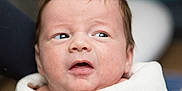 Amari is registered to the contest to win money with this photo: baby, infant, face, expression, blanket, wrapped, newborn, skin, person, portrait, cute, head, young, indoors, clothing, soft, warm, looking, closeup, human
