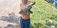 Maverick joined the competition — help win amazing prizes! child, boy, fish, fishing, glove, shirtless, jeans, sneakers, river, grass, dirt_road, trees, daylight, outdoor, nature, smile, person, water, recreational_activity, summer