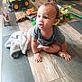 Kayden joined the competition — help win amazing prizes! toddler, child, floor, toy, dump_truck, action_figure, blanket, pacifier, wooden_floor, indoor, play, curious, sitting, expression, baby, hand, foot, clothing, car_seat, room