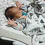 Kayden is registered to the contest to win money with this photo: baby, baby_seat, blanket, child, clothing, comfort, cozy, cushion, cute, face, indoors, infant, pacifier, person, raised_hands, rest, sleep, sleeping, soft_texture, wooden_floor