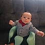 baby, barefoot, black_pants, bow_tie, checkered_shirt, child, clothing, couch, cute, expression, face, feet, green_baby_seat, hands, indoor, infant, person, seated, vest, young