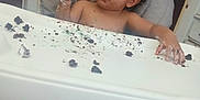 Kayden is registered to the contest to win money with this photo: baby, child, toddler, high_chair, cake, messy, frosting, food, crumbs, face, hands, indoor, home, foot, curly_hair, expression, person, seat, table, graco