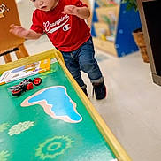 Marcelino joined the competition — help win amazing prizes! child, toddler, boy, portrait, standing, balancing, backward_cap, red_shirt, jeans, shoes, toy_table, toy_motorcycle, playroom, indoor, home, children_toy, road_map, colorful, plants, motion