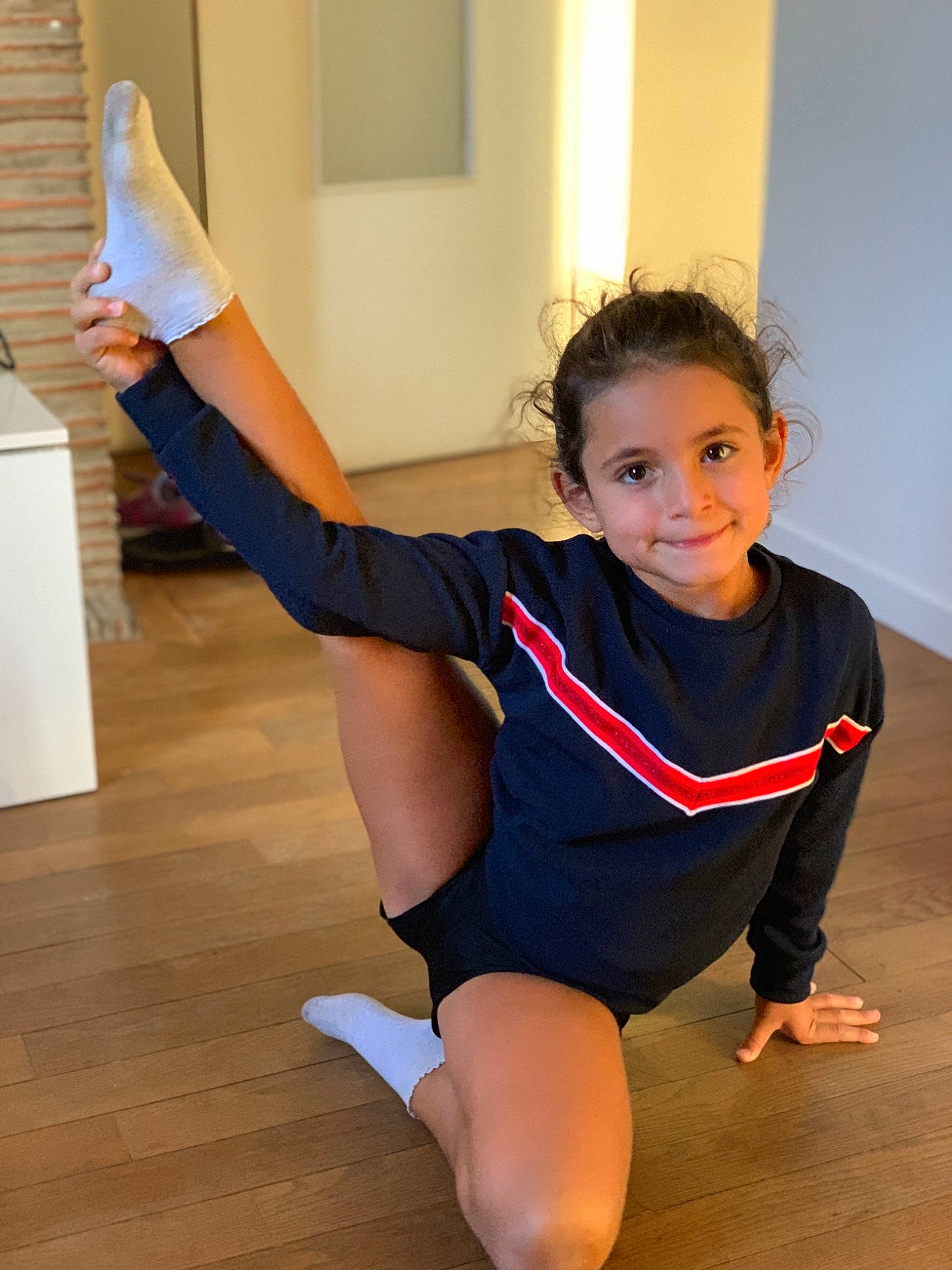 Helena participe au concours pour gagner de l'argent avec cette photo : barefoot, finger, floor, flooring, fun, happy, hardwood, human_body, human_leg, joint, joy, knee, leg, performing_arts, person, shoulder, sleeve, sportswear, standing, thigh