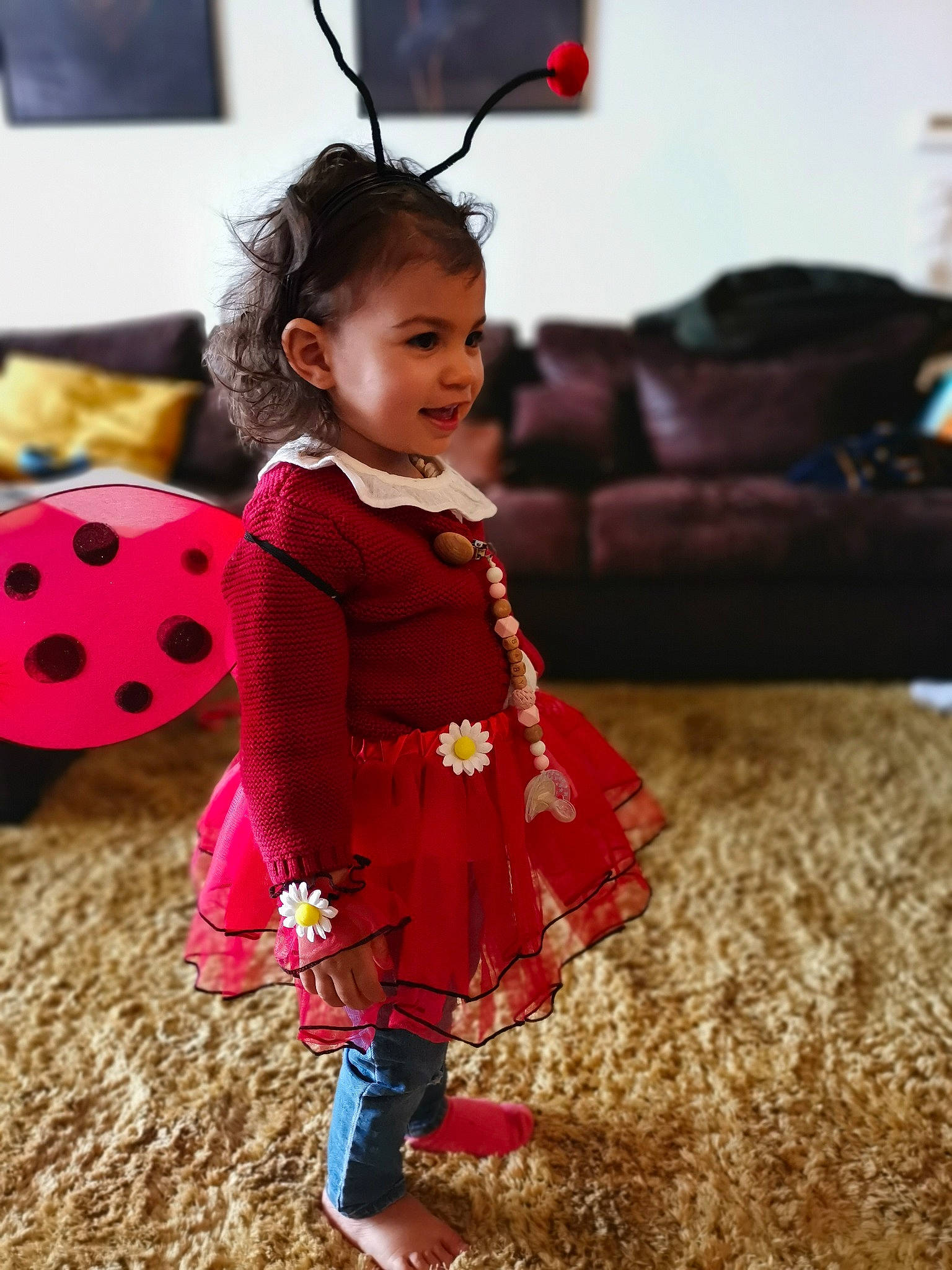 Lya a rejoint le concours — aidez-le/la à gagner de superbes lots ! baby, baby_toddler_clothing, child, dress, entertainment, event, fashion_design, fawn, flooring, fun, happy, head, magenta, pattern, person, pink, sitting, television, toddler, tradition