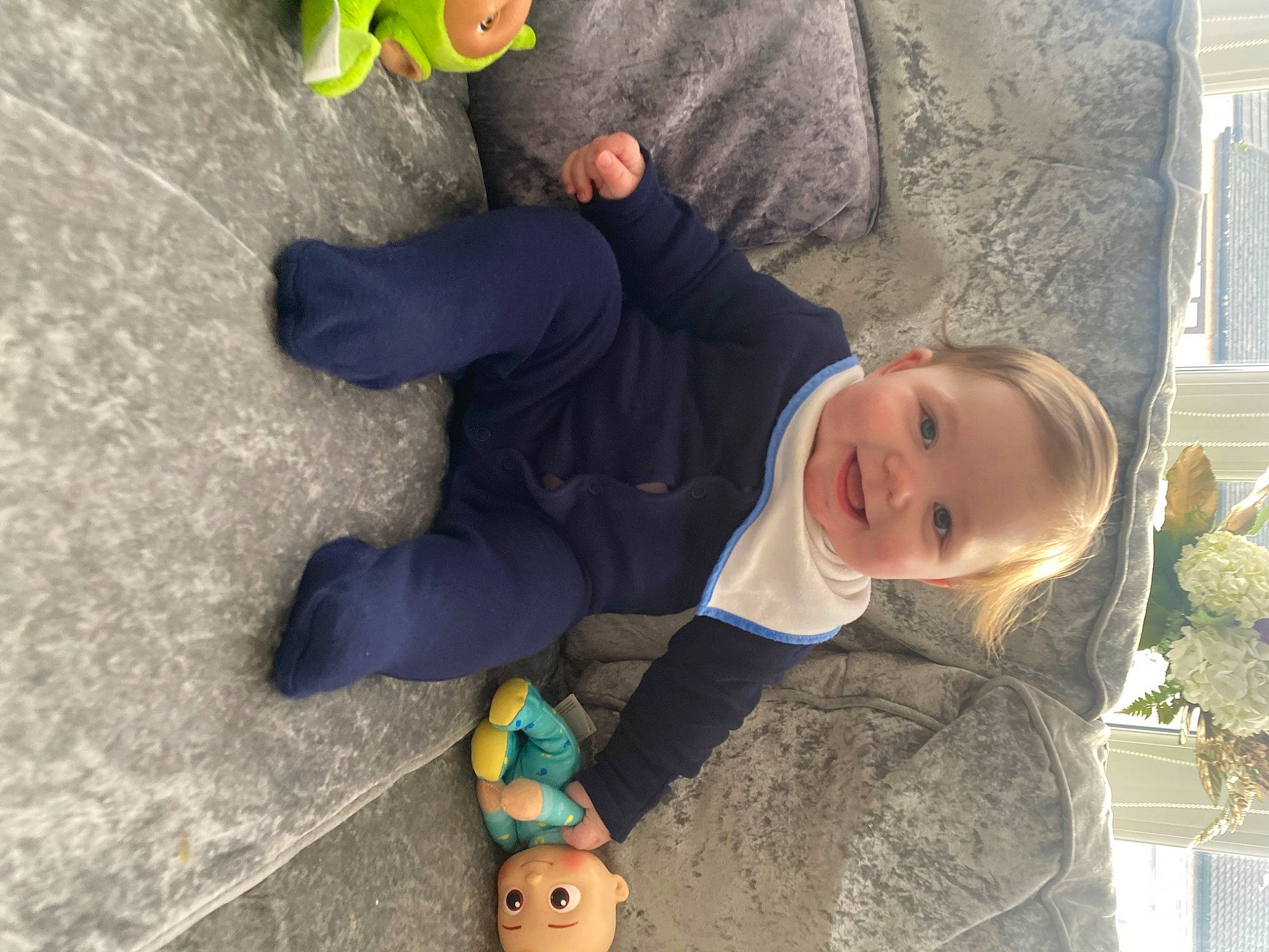 Andrew is registered to the contest to win money with this photo: baby, baby_toddler_clothing, child, flooring, fun, grass, jacket, joy, people, person, sitting, smile, toddler, tree, wood