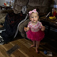 Ruby joined the competition — help win amazing prizes! toddler, girl, pink_tutu, headband, barefoot, snack, living_room, recliner, blanket, table, fast_food, floor, wooden_floor, curious, indoors, child, person, furniture, drink, toy