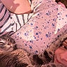 bed, blanket, cat, close_up, cozy, cuddle, floral_pattern, fur, indoor, nose_ring, paw, person, pet, pillow, relaxed, selfie, sleeping_cat, smile, striped_shirt, whiskers