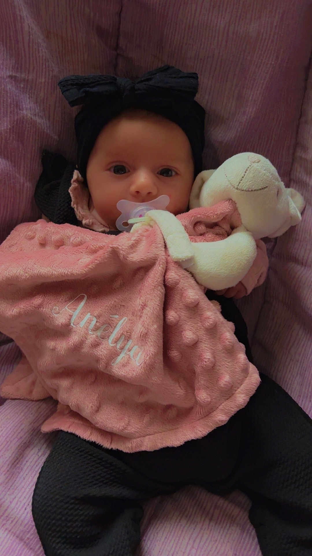 Anelya participe au concours pour gagner de l'argent avec cette photo : baby, black_clothing, blanket, child, closeup, comfort, cozy, cute, face, headband, indoors, infant, pacifier, pink_background, pink_blanket, portrait, rest, sleeping_area, soft_toy, stuffed_animal