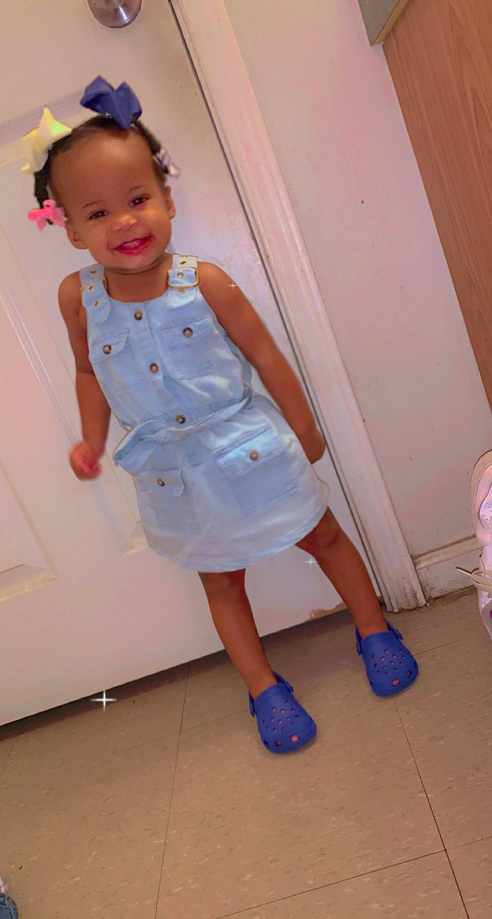 Lay is registered to the contest to win money with this photo: baby_toddler_clothing, day_dress, dress, face, flooring, fun, happy, human_leg, joy, leg, magenta, one_piece_garment, person, pink, purple, shoe, skin, sleeve, smile, standing