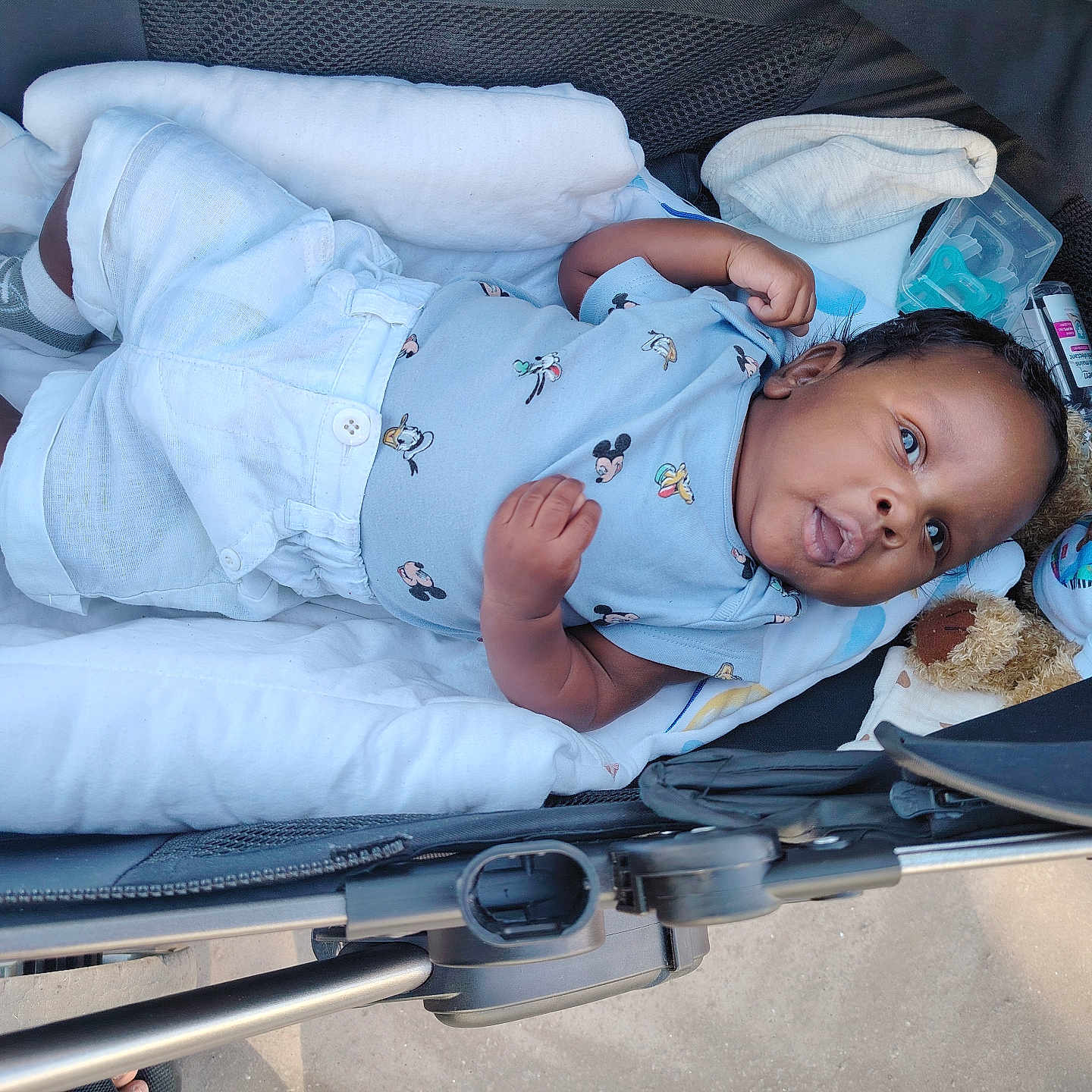 Djawël participe au concours pour gagner de l'argent avec cette photo : baby, blanket, child, clothing, comfort, cozy, cute, infant, lying_down, mickey_mouse, outdoor, person, portrait, resting, socks, soft_toys, stroller, sunlight, teddy_bear, young