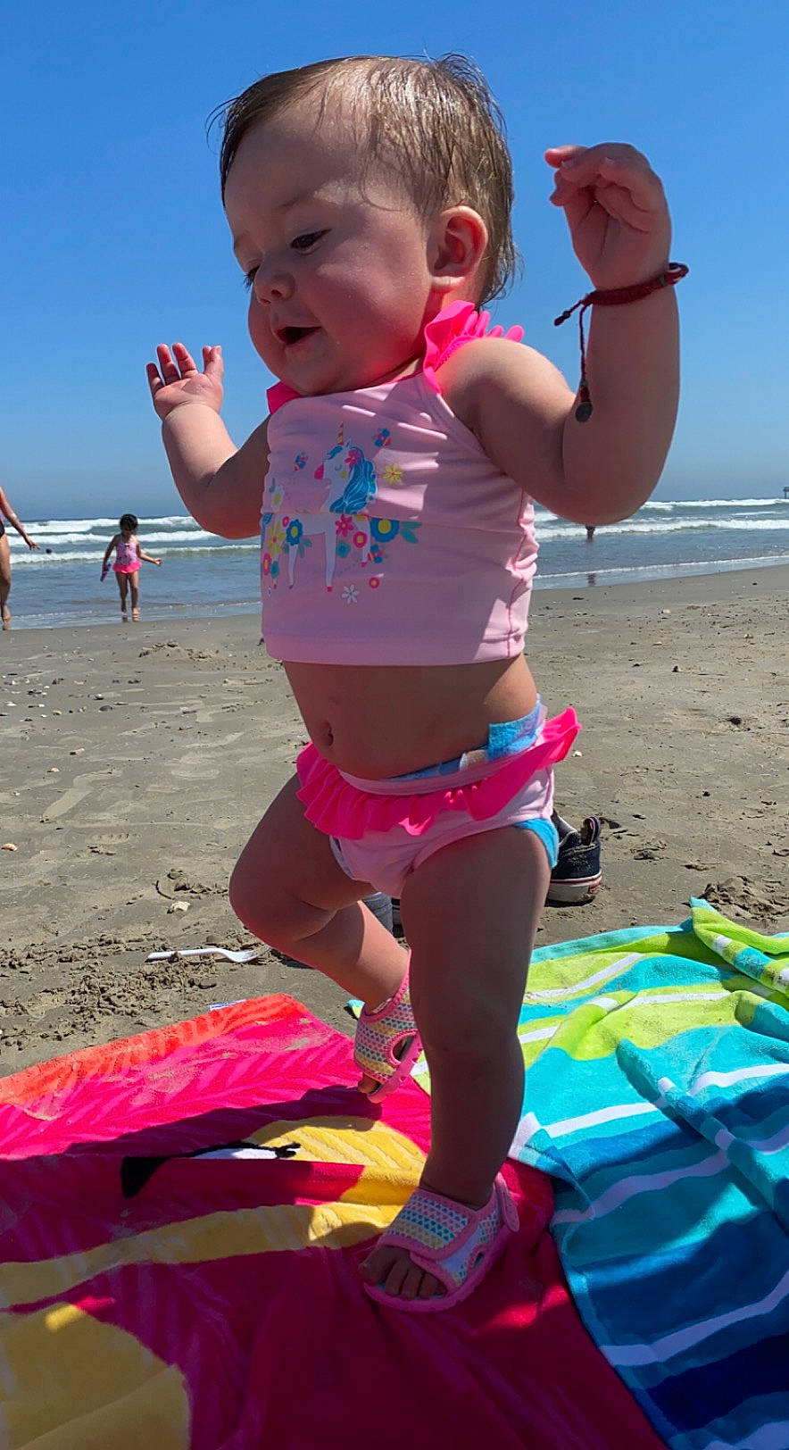 Ayviana joined the competition — help win amazing prizes! azure, beach, blue, body_of_water, fun, happy, leisure, light, people, people_on_beach, person, photograph, pink, sand, shorts, sky, summer, swimwear, toddler, travel