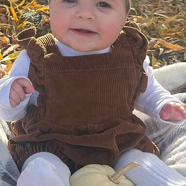 Imogen is registered to the contest to win money with this photo: baby, child, bow, corduroy, outdoor, blanket, pumpkin, fall, autumn, leaves, smile, cute, person, headwear, sitting, white_pumpkin, plaid, cozy, nature, seasonal