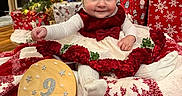 Imogen is registered to the contest to win money with this photo: baby, child, christmas_tree, presents, holiday, festive, red_dress, white_bow, blanket, smile, indoor, decorations, cozy, celebration, infant, cute, warm, holiday_season, christmas_stocking, wrapped_gifts