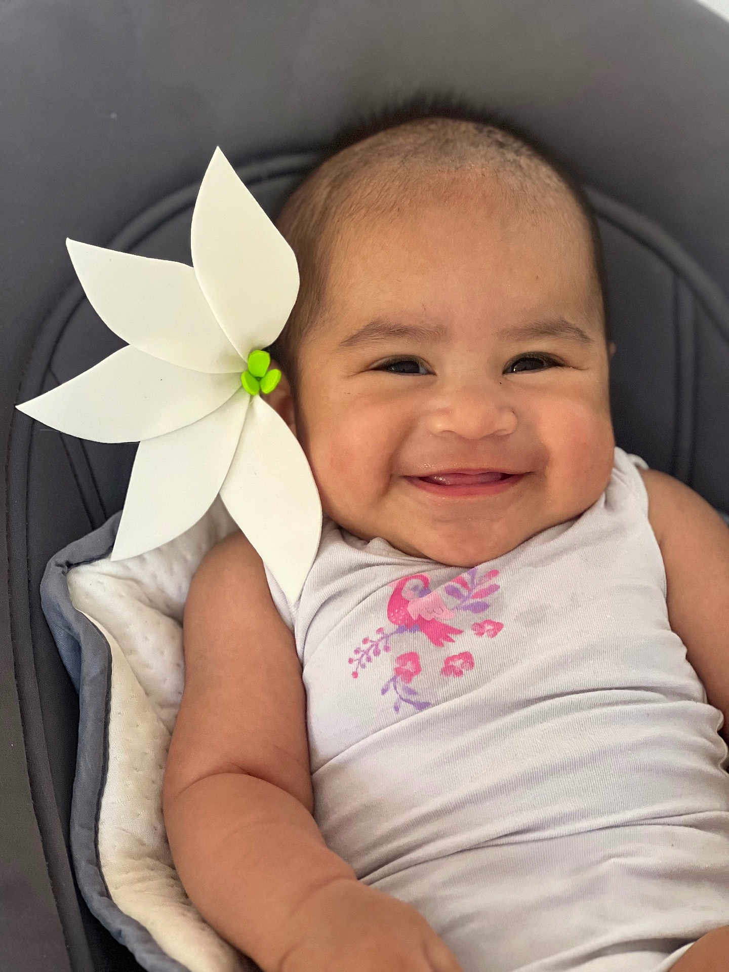 Heiitiragni participe au concours pour gagner de l'argent avec cette photo : baby, smiling, white_flower, tank_top, pink_bird, flower_print, cushion, happy, infant, child, portrait, close_up, skin, head, arm, baby_clothes, cute, indoors, relaxed, seated