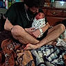Atlas joined the competition — help win amazing prizes! baby, man, newborn, blanket, bed, furniture, indoor, person, facial_expression, holding, casual_clothing, chain_necklace, wooden_drawer, water_bottle, pacifier, home, relaxed, sitting, intimate, portrait