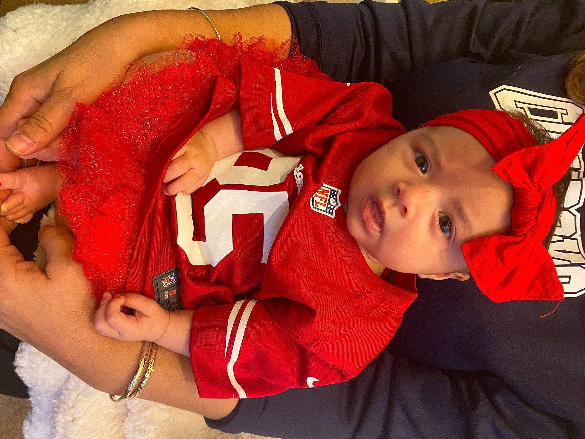 Davina joined the competition — help win amazing prizes! baby, carmine, child, comfort, finger, fun, gesture, hand, happy, hat, headwear, jersey, jewellery, person, player, red, sleeve, sports_uniform, sportswear, t_shirt