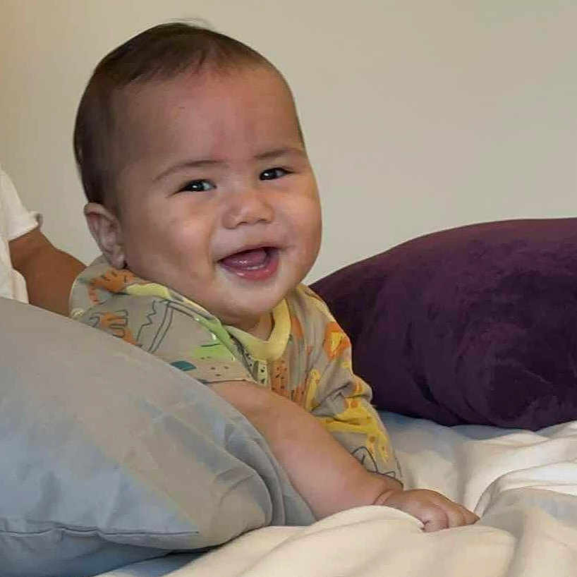 Christian M Fasavalu joined the competition — help win amazing prizes! baby, bed, blanket, child, comfort, cute, face, happy, indoor, infant, onesie, person, pillow, rest, room, sleepwear, smiling, soft, toddler, young