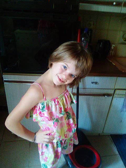 Coco a rejoint le concours — aidez-le/la à gagner de superbes lots ! cabinetry, child, cooktop, flooring, fun, hair, happy, home_appliance, homemaker, human_leg, joy, kitchen, kitchen_appliance, kitchen_stove, person, room, shorts, sitting, smile, t_shirt