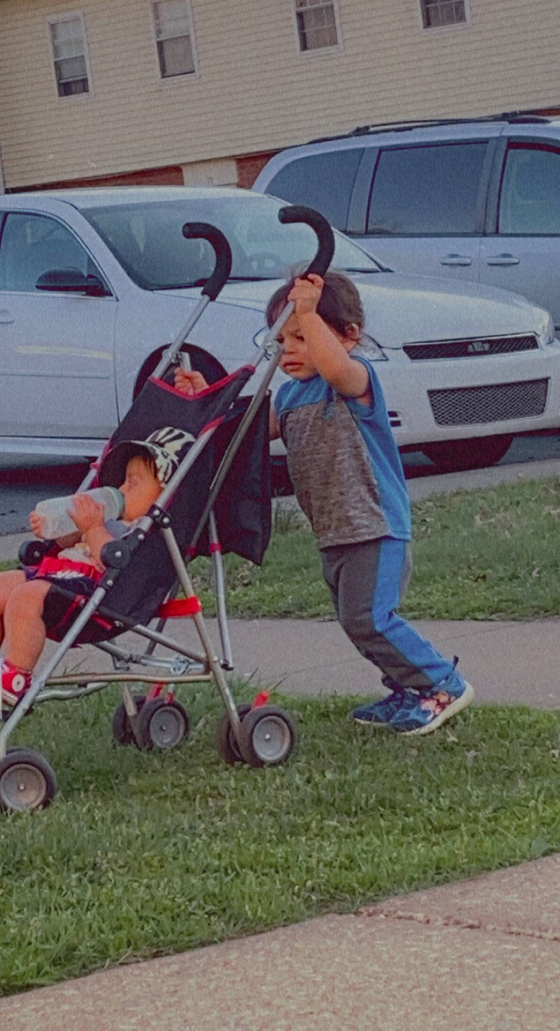 William is registered to the contest to win money with this photo: auto_part, automotive_exterior, automotive_wheel_system, baby_carriage, baby_products, bumper, car, family_car, grass, grille, jeans, land_vehicle, motor_vehicle, person, recreation, rolling, tire, toddler, vehicle, vehicle_door