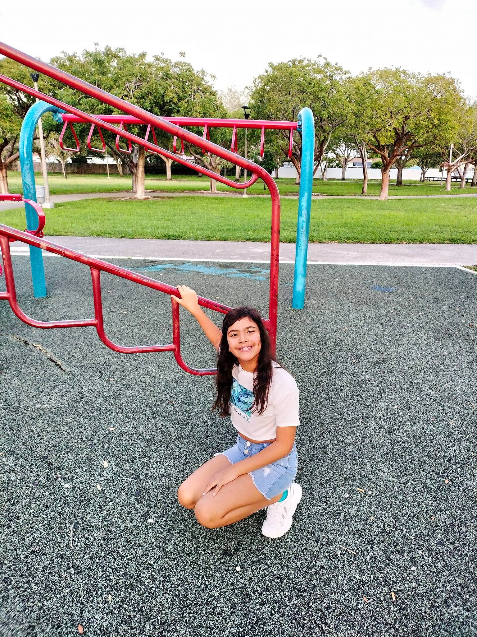 Angie joined the competition — help win amazing prizes! asphalt, city, fun, grass, joy, leisure, nonbuilding_structure, outdoor_play_equipment, person, plant, play, playground, pole, recreation, road, road_surface, sitting, sky, smile, t_shirt