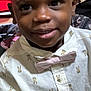 child, boy, smile, portrait, indoor, shirt, bow_tie, bunny_pattern, cute, face, expression, young, person, clothing, red_curtain, background, happy, closeup, casual, fashion