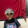 child, smiling, boy, cap, tshirt, spiderman, indoor, curtain, window, clothing, portrait, happy, person, casual, cute, dark_skin, short_sleeves, standing, fashion, youth