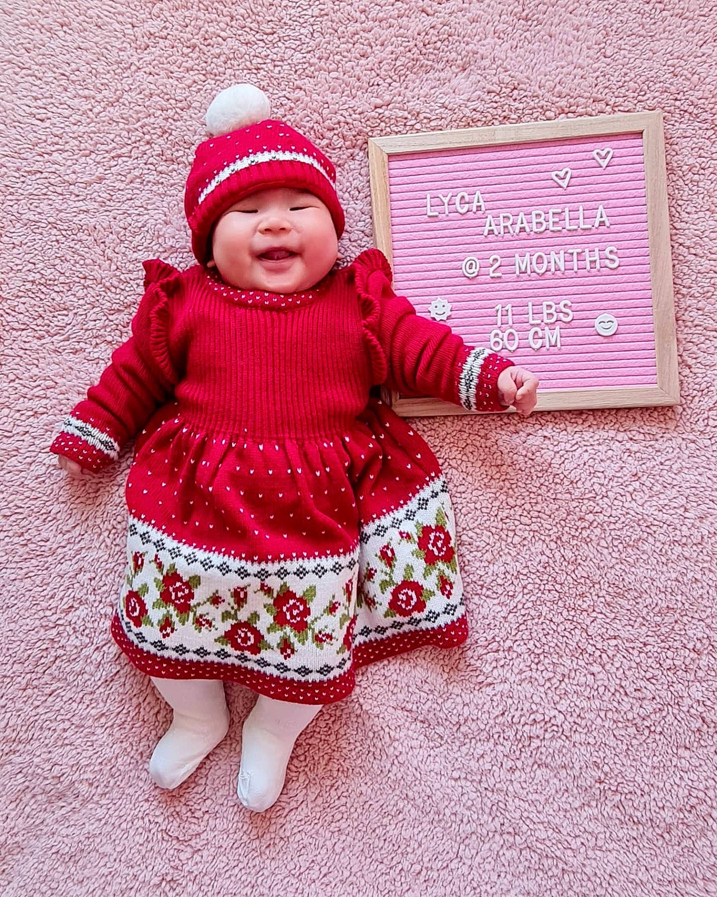 Lyca is registered to the contest to win money with this photo: baby, baby_toddler_clothing, cap, clothing, dress, face, flooring, hat, headgear, headwear, jacket, magenta, pattern, person, pink, purple, sleeve, textile, toddler, violet