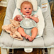 Collins joined the competition — help win amazing prizes! baby, smiling, baby_rocker, blanket, cushion, wooden_floor, infant, happy, clothing, face, feet, person, indoor, seat, head, comfort, cute, child, sitting, expression
