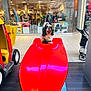 animal, black_and_white, cute, display, dog, floor, fur, indoor, light, mall, pet, play, red, reflection, ride, shopping, shopping_mall, store, stroller, toy_boat