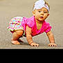 baby, child, crawling, pink_clothing, headband, white_flower, outdoor, pavement, curious, young_child, colorful_shorts, barefoot, infant, person, cute, summer, playful, skin, portrait, daylight