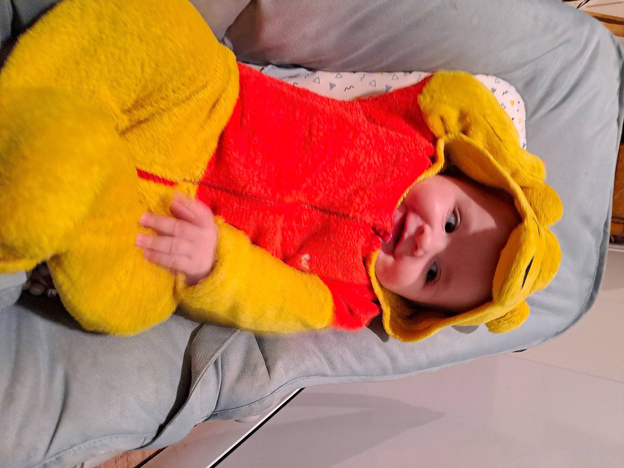 Luna a rejoint le concours — aidez-le/la à gagner de superbes lots ! baby, baby_toddler_clothing, bedtime, child, comfort, facial_expression, finger, flooring, fun, gesture, headwear, human_body, human_leg, linens, mammal, orange, person, room, thumb, toddler