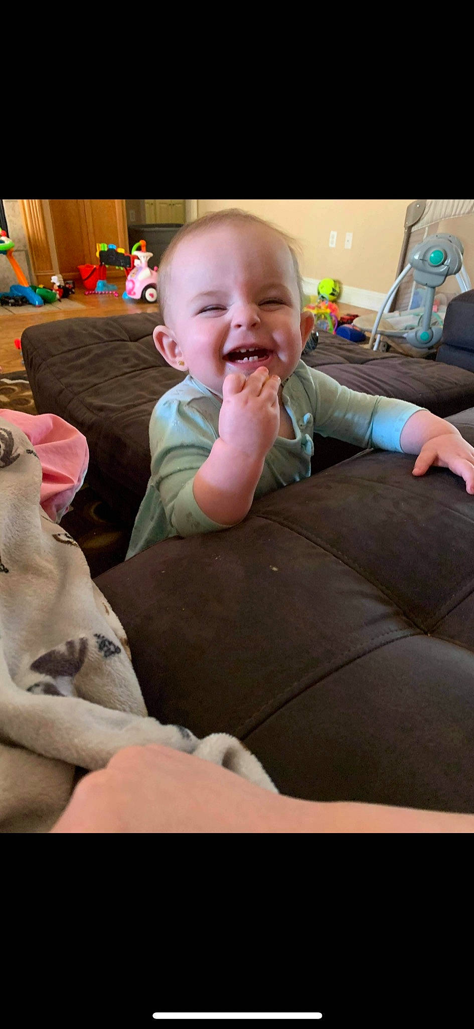 Blakely is registered to the contest to win money with this photo: baby, baby_toddler_clothing, cheek, child, comfort, couch, electronic_device, eye, finger, fun, happy, joy, lap, living_room, person, play, room, sitting, skin, smile