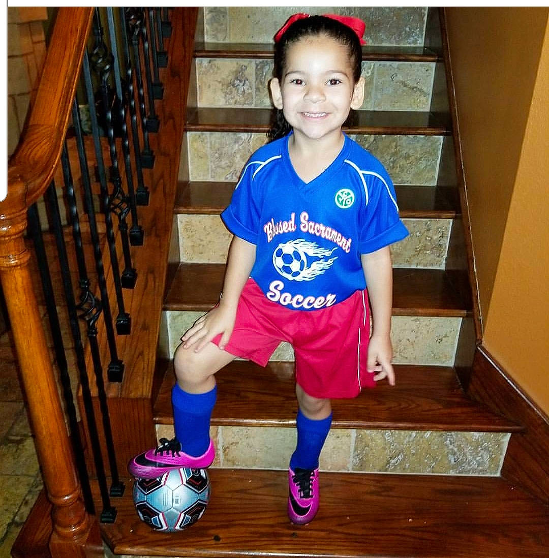 Coco is registered to the contest to win money with this photo: blue, boy, child, clothing, day, electric_blue, footwear, girl, joy, leg, outerwear, person, product, purple, shoe, shoulder, sports_uniform, sportswear, standing, t_shirt